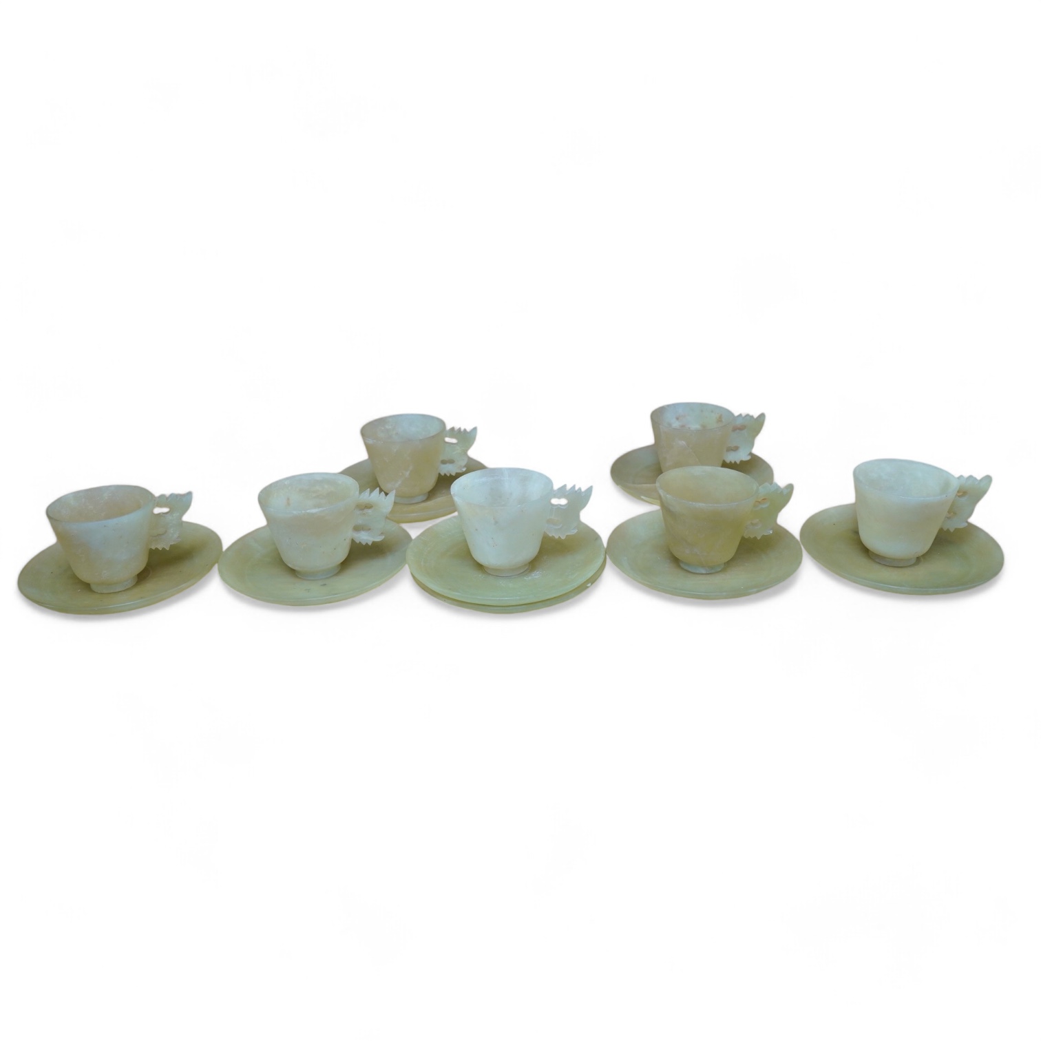 A set of seven Chinese bowenite jade cups and eight saucers, 11cm in diameter. Condition - fair to good